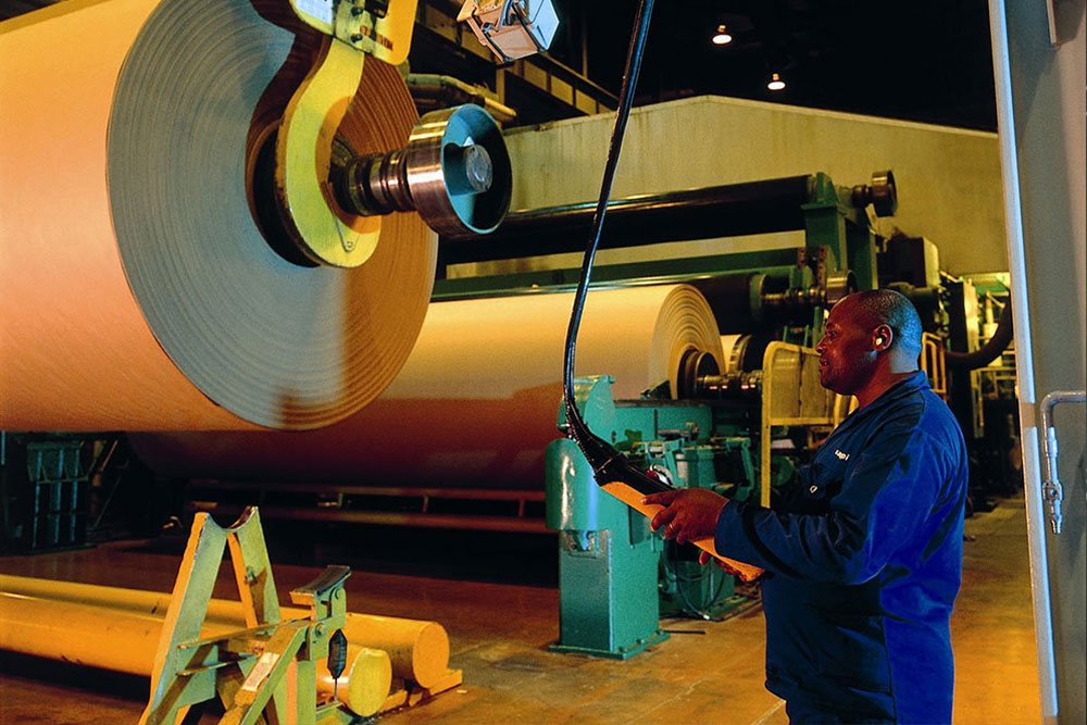 Papermill employee operating paper manufacturing machinery