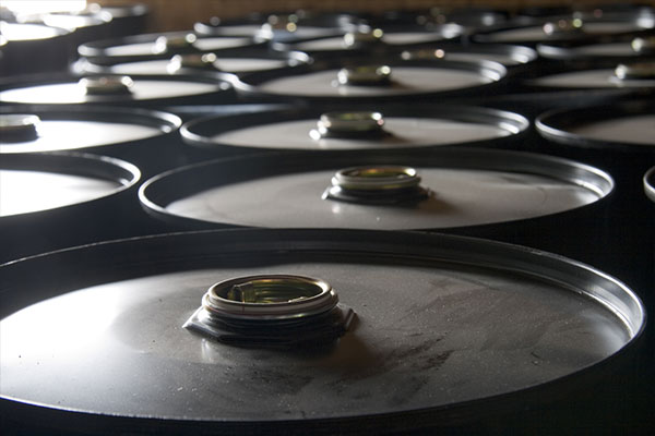 Group of black oil barrels filled with used oil
