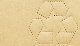 Recycling Symbol Cutout on Brown Cardboard Background