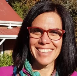 Nicky Jones smiling outdoors with glasses