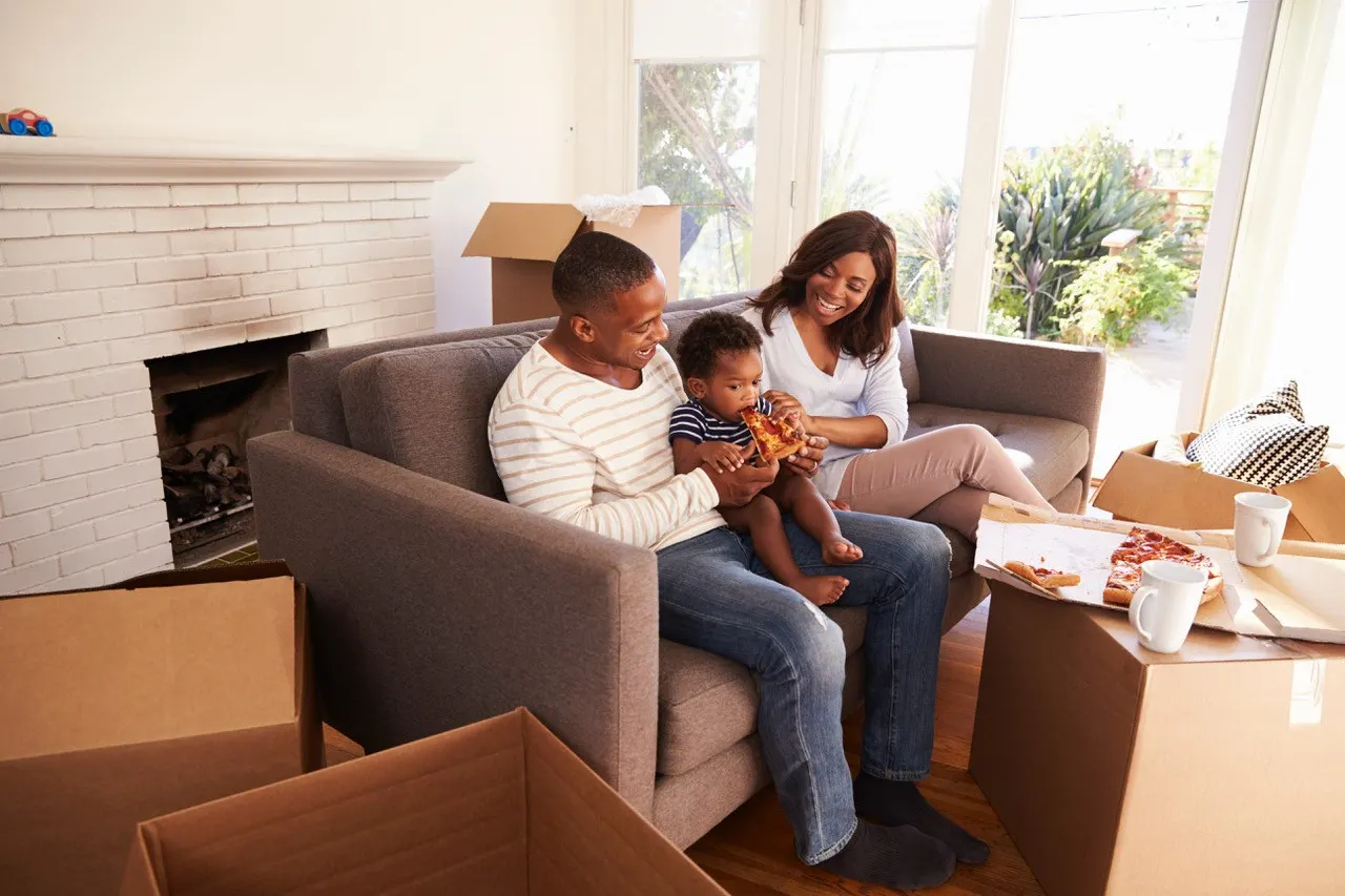 family eating pizza in new home with boxes