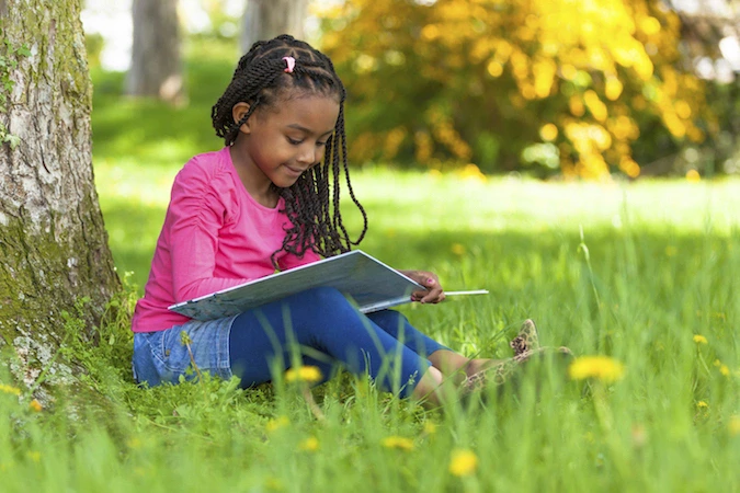 young girl reading book outdoors young girl reading book outdoors