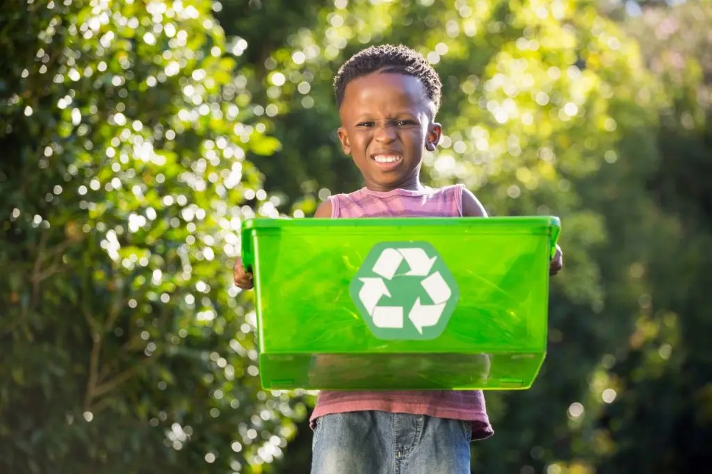 Child Holding Recycling Bin Outdoors
