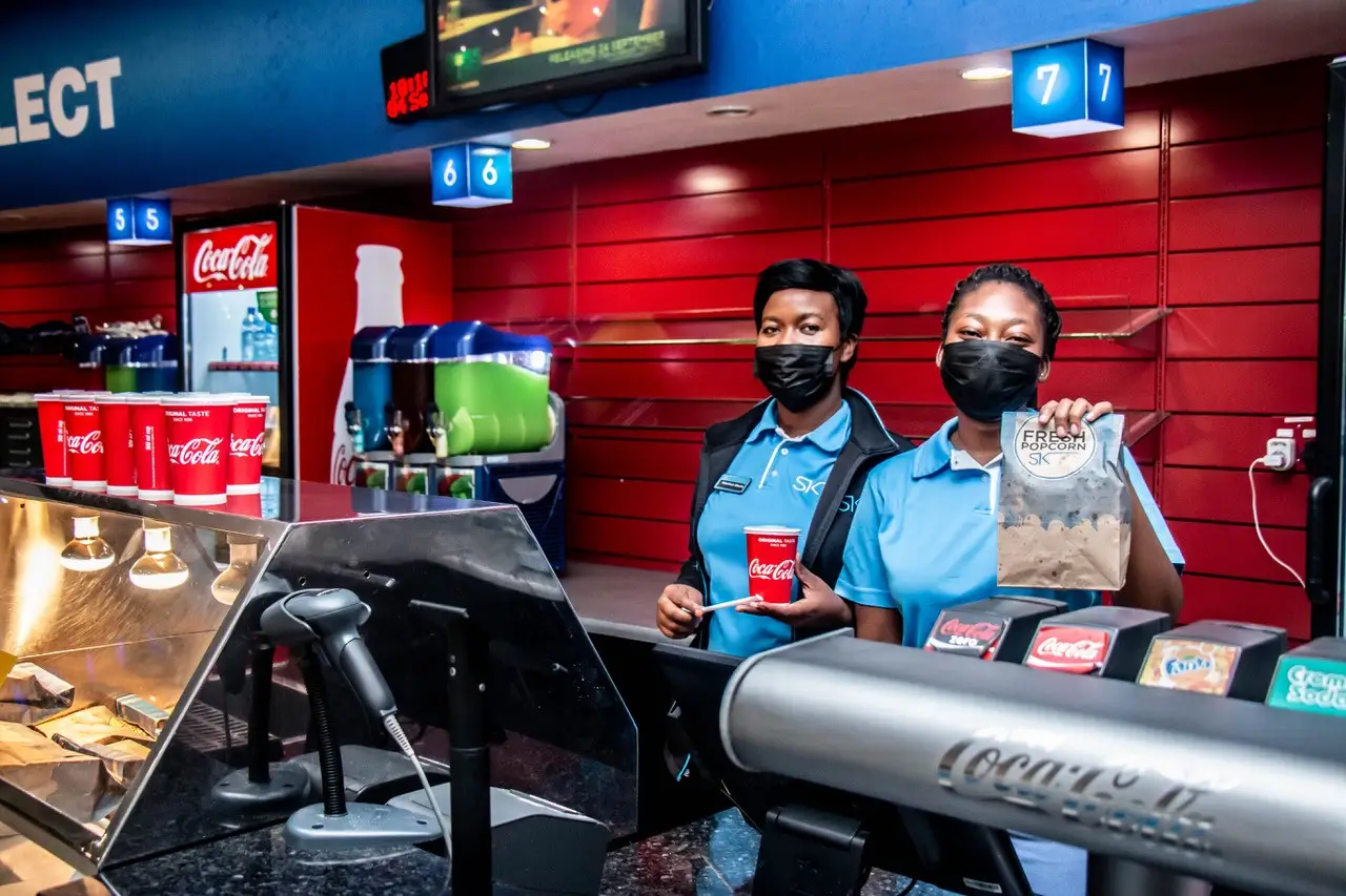 Cinema Staff Holding Paper Popcorn Bag and Drink Cup Cinema Staff Holding Paper Popcorn Bag and Drink Cup